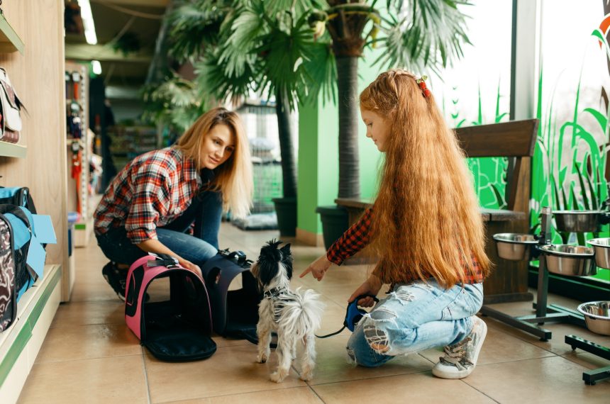 Mother with daughter choosing bag in pet store